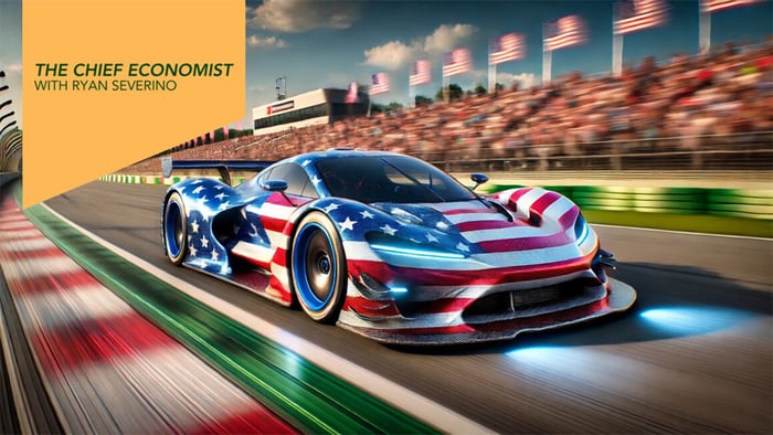 An American flag-themed race car speeding on a racetrack with a blurred crowd in the background, accompanied by the text 'The Chief Economist with Ryan Severino' in a yellow banner.