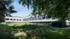 Exterior of The Press life sciences and innovation campus in Foxton, Cambridge, surrounded by trees and landscaped grounds.