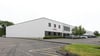 Exterior view of a Prestige Park industrial building in East Hartford, Connecticut, featuring white warehouse and flex-industrial space with adjacent parking.